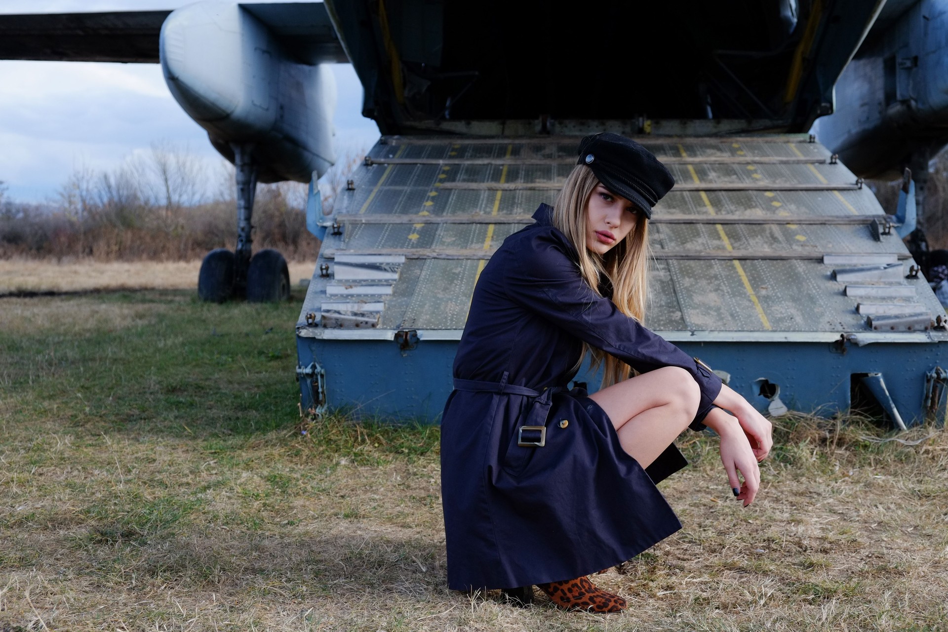 Portrait of a young and attractive stewardess by the old plane
