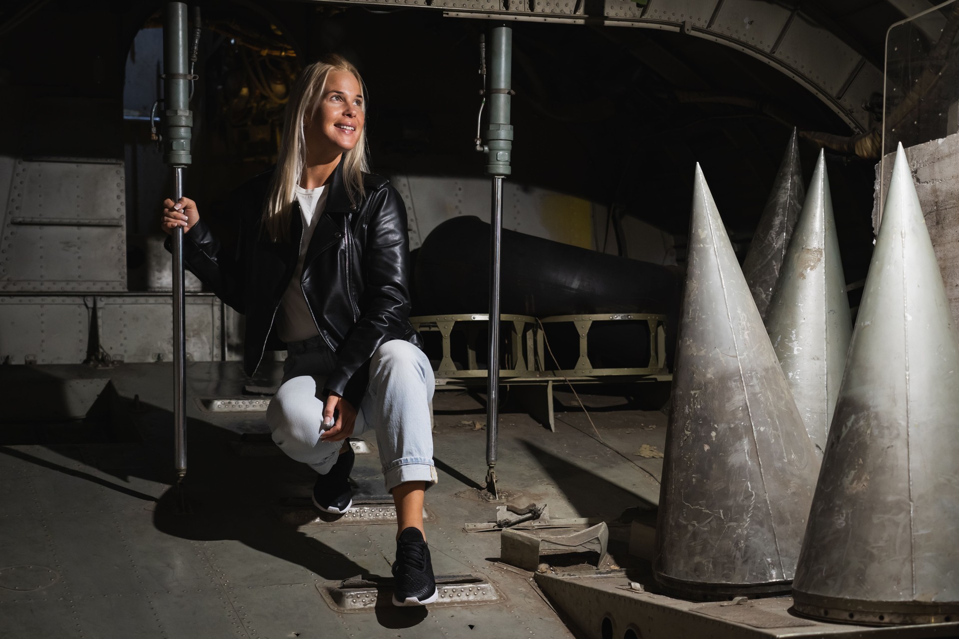 A blonde girl inside a military decommissioned An-12 cargo plane.